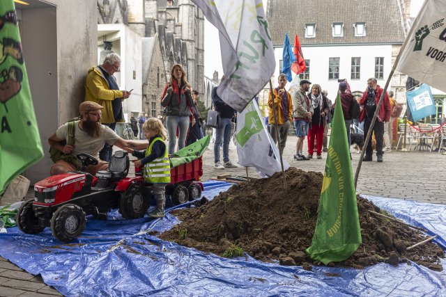 Actiegroep met vlaggen, aarde en kleine tractor