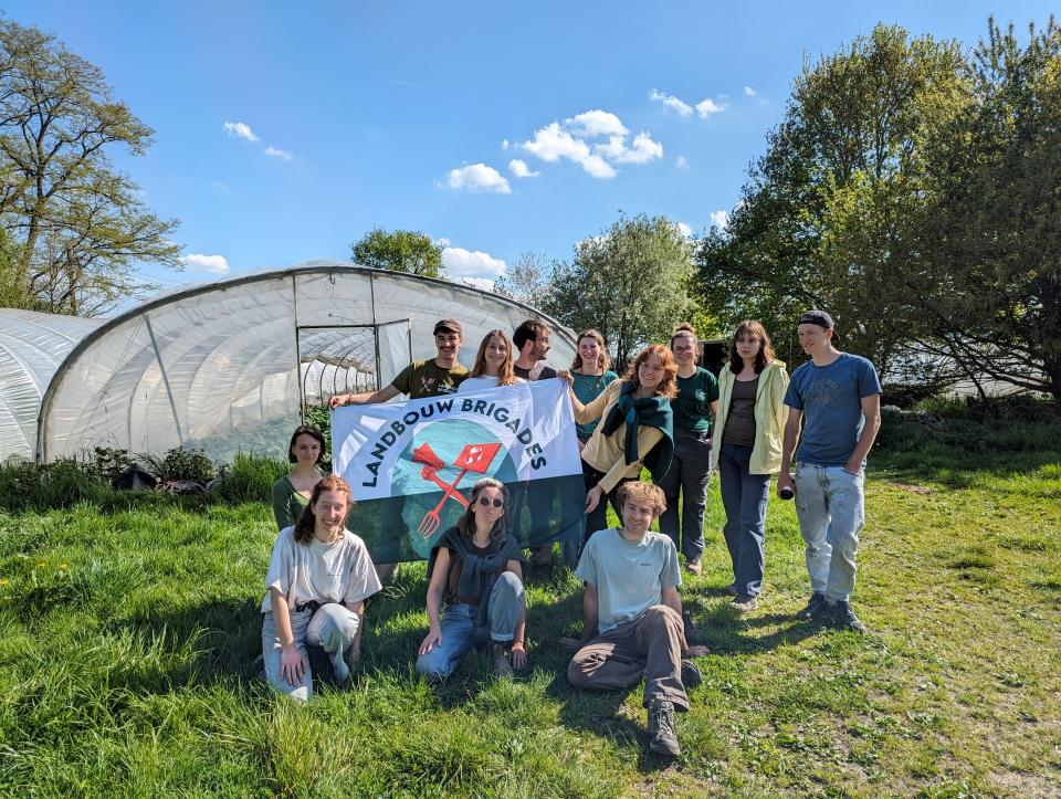 Brigadisten met vlag De Landbouwbrigades