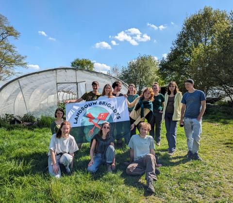 Brigadisten met vlag De Landbouwbrigades